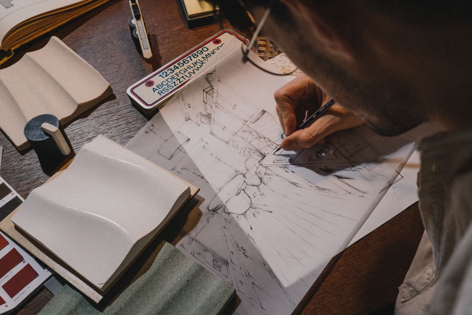 A bathroom being sketched out at a desk with material samples.